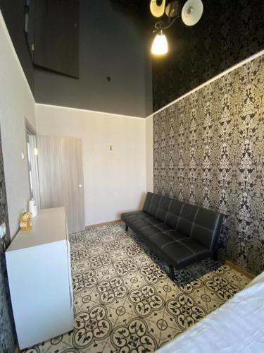 a black couch in a room with a wall at Морской бриз in Odesa