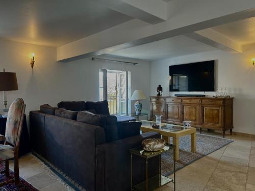 un salon avec un canapé et une télévision dans l'établissement Le Petit Prieuré, à Châteauneuf-du-Pape