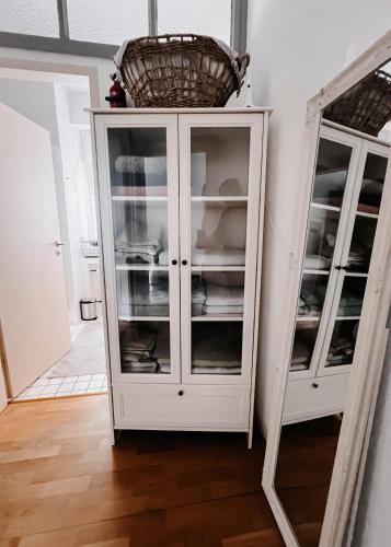 a white cabinet with a basket on top of it at Im alten Pastorat in Grevenbroich