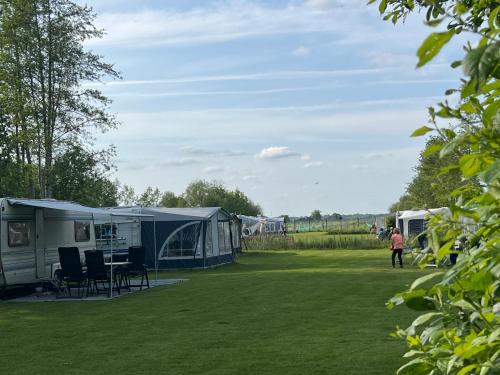 a group of tents and chairs in a field at CAMPING PITCH with electricity bring you're OWN CARAVAN OR TENT in Ruinerwold