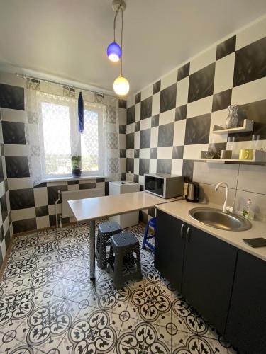 a kitchen with a table and a sink in it at Морской бриз in Odesa