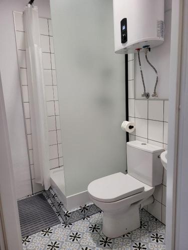 a white bathroom with a toilet and a shower at Stare Gniezno Centrum Miasta in Gniezno