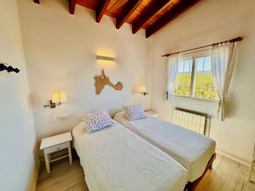 a bedroom with two beds and a window at Casa Stefi - Astbury Formentera in Es Arenals