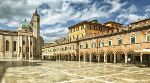 a large building with a clock tower in a courtyard at Entire Private Floor in an 1800s Frescoed Villa with Historic Park - Villa Mastrangelo in Colli del Tronto