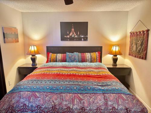 a bedroom with a large bed with two lamps at Float Pool, Telescope, Hot Tub, Sauna, BBQ, Mountain Views in Joshua Tree