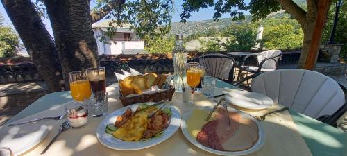 a table with plates of food and glasses of orange juice at Archontiko Kantartzi in Portariá