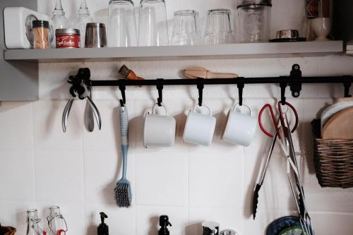 a rack of coffee cups and utensils on a wall at Im alten Pastorat in Grevenbroich