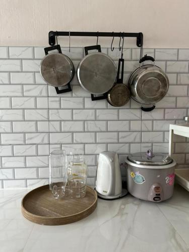 a kitchen counter with glasses and pots and pans at Homestay Kakak Adek 2 in Simpang Ampat
