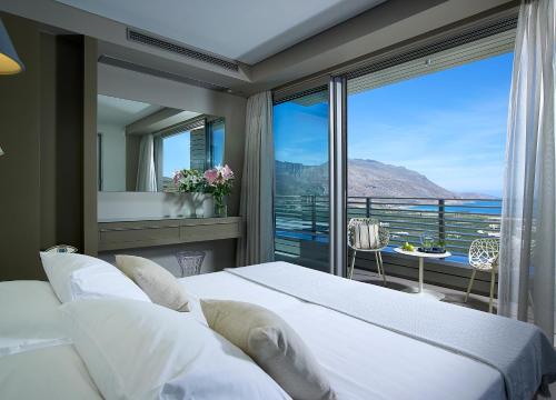 a bedroom with a bed and a large window at Youphoria Sea View Villas in Kissamos