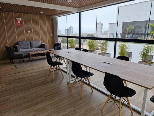 リマにあるApartamento entero en San Miguelの大きな木製テーブルと椅子付きの会議室