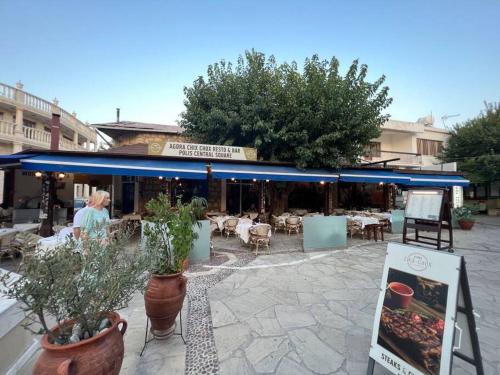 a patio with tables and chairs and potted plants at Pelagos Panorama 2B, Seaview, Pool in Chlorakas