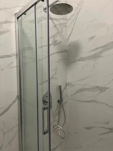 a shower with a glass door and a shower head at Room 28 in Conversano