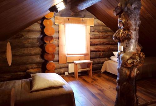a bedroom in a log cabin with a window at Kelo Villa for 8, with hot tub, by lake Päijänne in Jyväskylä