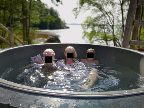 three children swimming in a hot tub in the water at Kelo Villa for 8, with hot tub, by lake Päijänne in Jyväskylä
