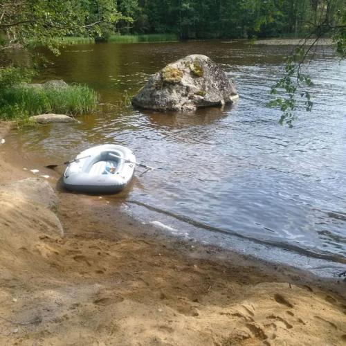 a white boat sitting on the shore of a river at Kelo Villa for 8, with hot tub, by lake Päijänne in Jyväskylä
