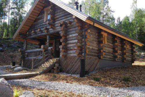 a log cabin with a porch and a staircase at Kelo Villa for 8, with hot tub, by lake Päijänne in Jyväskylä