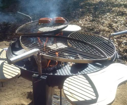 a grill with hot dogs on top of it at Kelo Villa for 8, with hot tub, by lake Päijänne in Jyväskylä