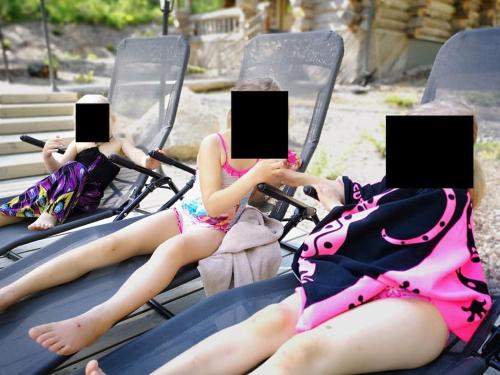 two girls in bathing suits sitting in chairs with their laptops at Kelo Villa for 8, with hot tub, by lake Päijänne in Jyväskylä