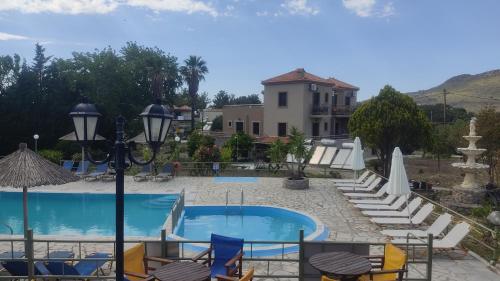 a resort with a pool and chairs and a building at Ourania Studios in Petra