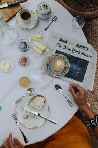 a table with plates and utensils and a newspaper at Ottmanngut Suite and Breakfast in Merano