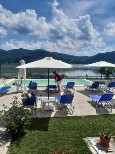 a man standing under an umbrella next to a swimming pool at Villa Rustica in Gornea