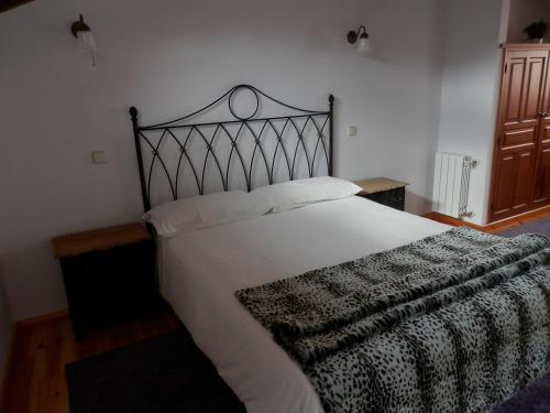 a bedroom with a large bed with a black and white blanket at La Casona de Castilnovo - Gay Men Only in Valdesaz
