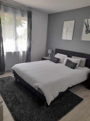 une chambre avec un grand lit avec des draps et des oreillers blancs dans l'établissement La bastide de Calés, à Lamanon