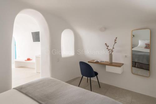 a bedroom with a bed and a mirror and a chair at Aspaki by Art Maisons in Oia