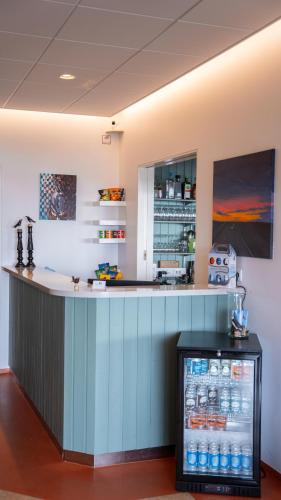 a bar in a room with a drink cooler at Hótel Flókalundur in Brjánslækur
