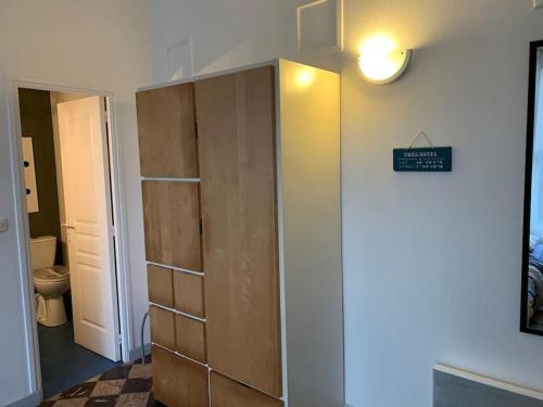 un placard dans une salle de bain avec une lumière sur le mur dans l'établissement Vacances à 50m de la plage et de la mer, à Trégastel