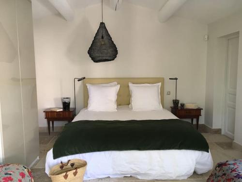 une chambre avec un grand lit avec des oreillers blancs dans l'établissement Villa Saignon les plus beaux villages de France, à Saignon