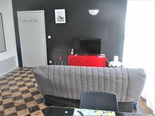 a living room with a couch and a television at Vacances à 50m de la plage et de la mer in Trégastel