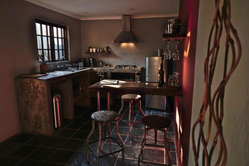 a kitchen with a counter and stools in it at Villa La Mercy Guest Suite, No load shedding or water outages in La Mercy