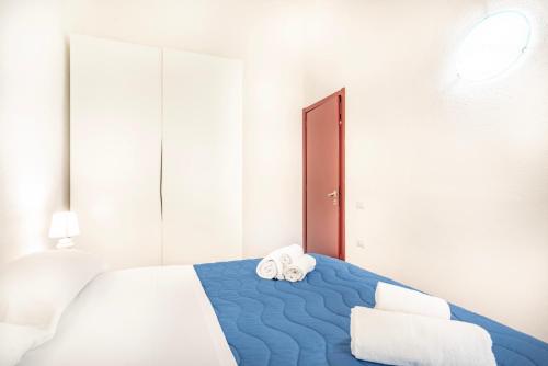 a bedroom with a blue bed with towels on it at Villetta degli Oleandri - Geremeas 2 in Geremeas