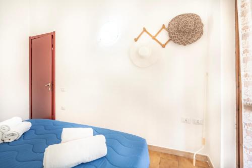 a bedroom with a blue bed and a white wall at Villetta degli Oleandri - Geremeas 2 in Geremeas