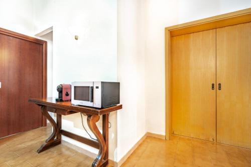 a microwave sitting on top of a wooden table at Villetta degli Oleandri - Geremeas 2 in Geremeas