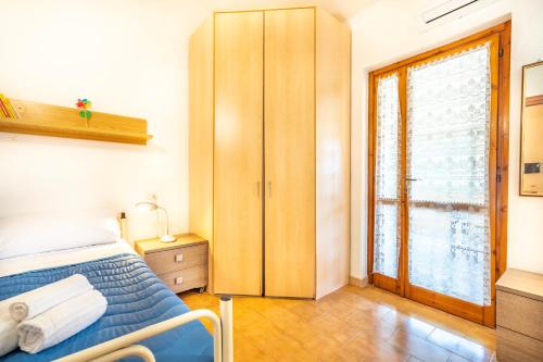 a bedroom with a bed and a large window at Villetta degli Oleandri - Geremeas 2 in Geremeas