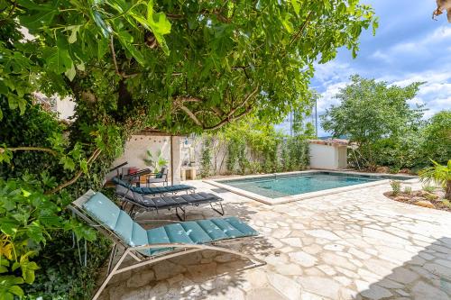 - un groupe de chaises et une piscine dans l'établissement MAISON DE MAITRE 230M² EN PLEIN COEUR DU VILLAGE, à Camps-la-Source