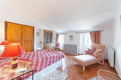 une chambre avec un lit et une chaise dans l'établissement MAISON DE MAITRE 230M² EN PLEIN COEUR DU VILLAGE, à Camps-la-Source