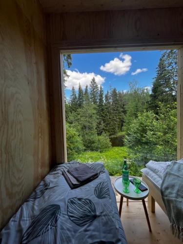 a bed and a table in a room with a window at KoloCabins - Hiitolanjoki 3 in Simpele