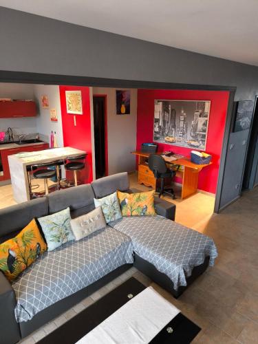 a living room with a couch and a kitchen at La Bastide du Canal avec piscine et clim in Carcassonne