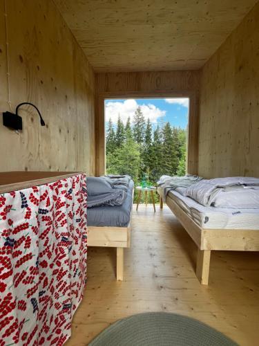 two beds in a room with a window at KoloCabins - Hiitolanjoki 3 in Simpele