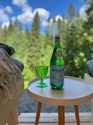 a bottle and a glass sitting on a table at KoloCabins - Hiitolanjoki 3 in Simpele