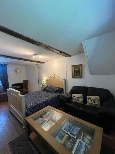 a living room with a bed and a couch at chambre d'hote a la ferme in Lengronne