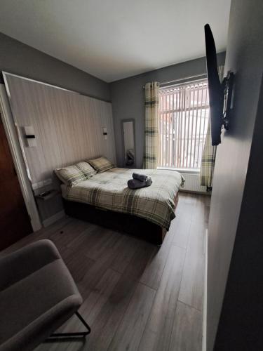 a bedroom with a bed and a chair and a window at dalesman hotel in Darlington
