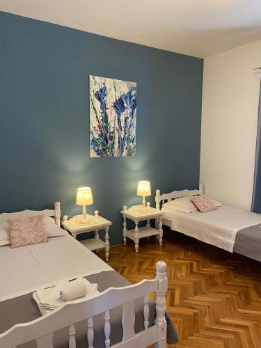 a room with three beds and a painting on the wall at Villa MirIva in Katuni