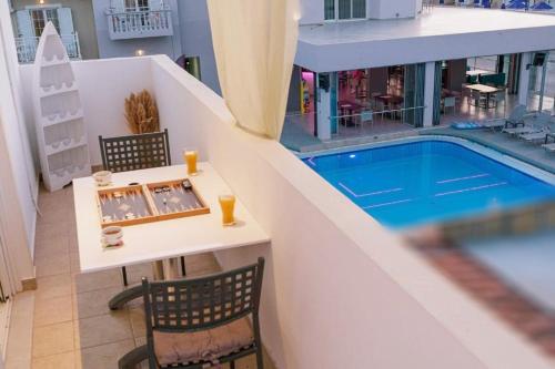 a view of a swimming pool in a building with a table and chairs at PEDRO NAVARINO ΙΙΙ Laganas in Laganas