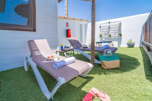 two chaise lounges on a lawn next to a house at El Paraíso Perdido in Conil de la Frontera