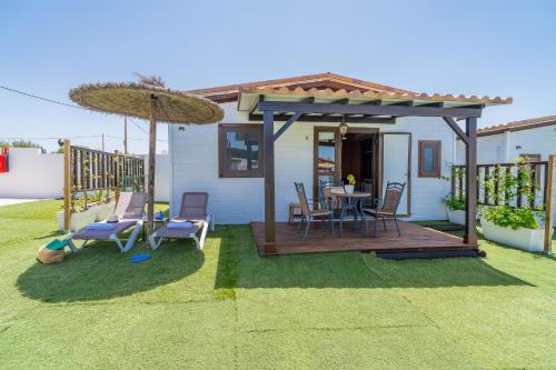 a house with a deck with a table and chairs at El Paraíso Perdido in Conil de la Frontera