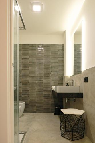 a bathroom with a sink and a shower at Camoma Aparthotel - Suites Apartments in Jesolo